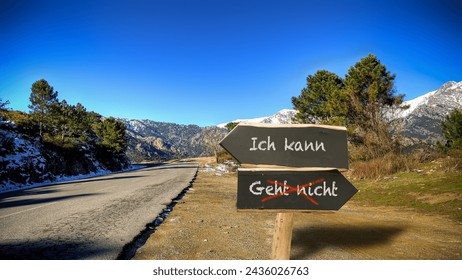 An image with a signpost pointing in two different directions in German. One direction points to I can, the other points to resignation.
