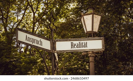 An image with a signpost pointing in two different directions in German. One direction points to reality, the other points to expectation