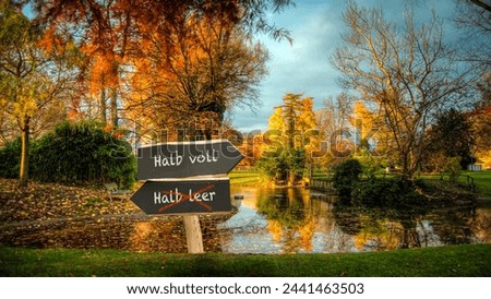 An image with a signpost pointing in two different directions in German. One direction points half full, the other points half empty.