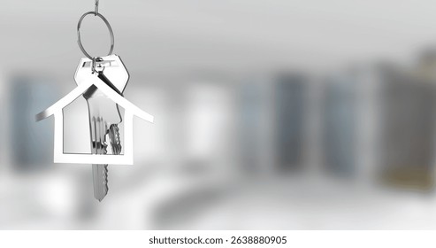Image of silver house keys hanging against blurred background with copy space. Relocation and real estate concept