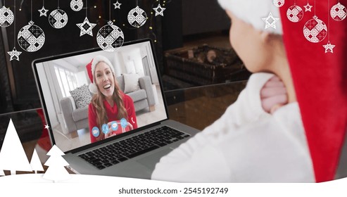 Image of snow falling over smiling woman in santa hat on laptop video call with her family. christmas, tradition and celebration concept digitally generated image. - Powered by Shutterstock