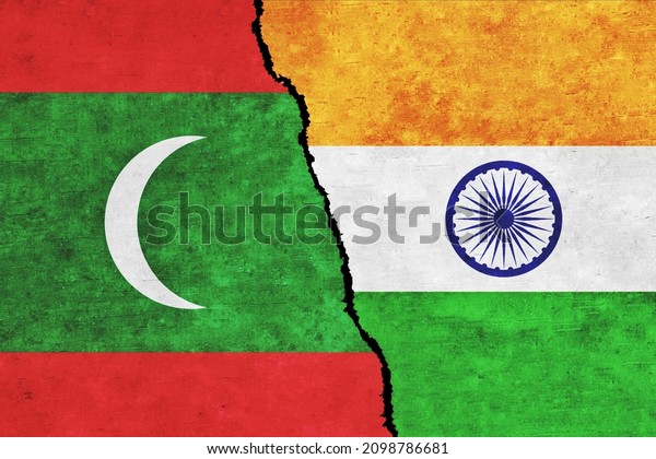 India and Maldives painted flags on a wall with\
a crack. India and Maldives conflict. Maldives and India flags\
together. India vs\
Maldives