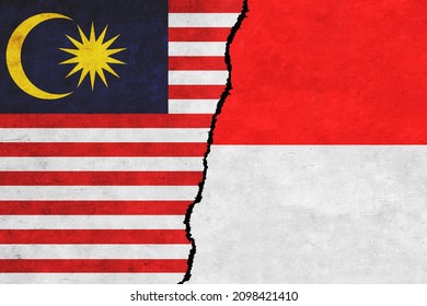 Indonesia and Malaysia painted flags on a wall with a crack. Indonesia and Malaysia relations. Malaysia and Indonesia flags together. Indonesia vs Malaysia