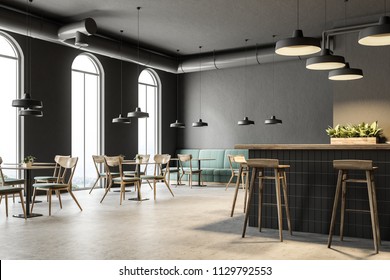 Industrial style bar corner with dark gray walls, a concrete floor, arched windows and wooden tables with chairs. Green sofas. 3d rendering mock up