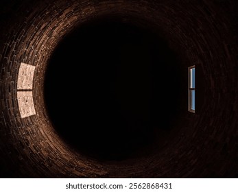 Inside a tall round brick tower with a single window.