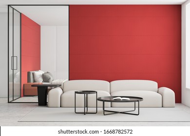 Interior of bright living room with red and white walls, concrete floor, comfortable white sofa with round coffee tables and bedroom in background. 3d rendering