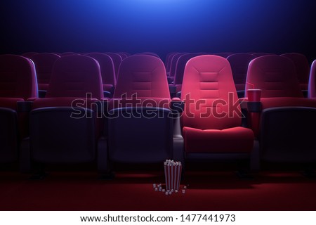Interior of empty dark cinema with rows of red seats with cup holders and popcorn. Concept of entertainment. 3d rendering toned image