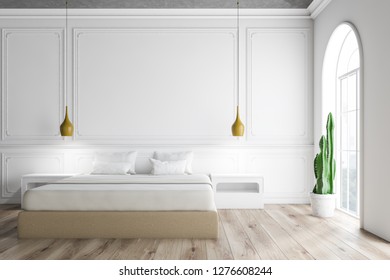 Interior of master bedroom with white walls, arched windows, wooden floor and beige master bed with white bedside tables. 3d rendering