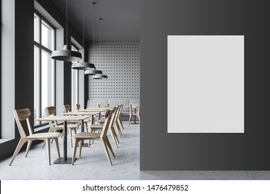 Interior of minimalistic cafe with gray walls, concrete floor, comfortable sofa and wooden tables with chairs. Vertical mock up poster on the wall. 3d rendering