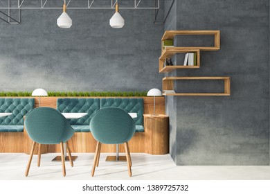 Interior Of Modern Coffee Shop With Concrete Walls, White Floor, Square White Tables And Comfortable Blue Sofas And Chairs. Wooden Shelves With Books And Bottles. 3d Rendering