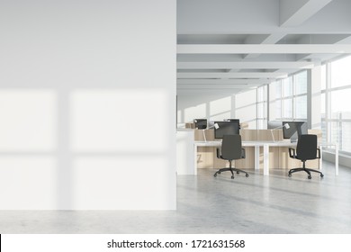 Interior Of Modern Industrial Style Open Space Office With White Walls, Concrete Floor, Rows Of Computer Tables And Panoramic Windows With Blurry Cityscape. Mock Up Wall. 3d Rendering