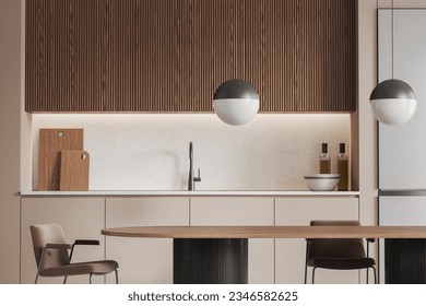 Interior of modern kitchen with beige walls, wooden cupboards, comfortable beige cabinets with built in sink and long dining table with chairs in foreground. 3d rendering - Powered by Shutterstock