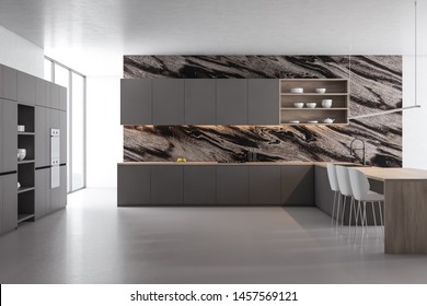 Interior of modern kitchen with black marble walls, concrete floor, gray countertops, shelves with dishes, wooden bar with stools and gray cupboard with built in ovens. 3d rendering