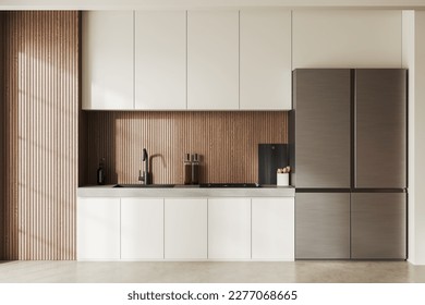 Interior of modern kitchen with white and wooden walls, concrete floor, white cabinets with built in sink and cooker and big fridge. 3d rendering