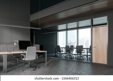 Interior Of Modern Open Space Office With Dark Gray Walls, Conference Room With Panoramic Window And Long Grey Meeting Table With Chairs. Computer Desk In Foreground. 3d Rendering