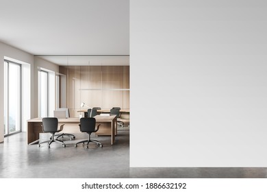 Interior of modern open space office with white and wooden walls, concrete floor and rows of computer tables. Meeting room in the background. Mock up wall to the right. 3d rendering