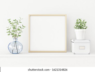 Interior poster mockup with square gold metal frame on the table with plants in blue vase, pot and box on empty white wall background. 3D rendering, illustration.