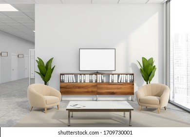 Interior Of Stylish Company Waiting Room With White Walls, Tiled Floor, Comfortable Beige Armchairs Near Coffee Table And Mock Up TV Screen. Panoramic Window With Blurry Cityscape. 3d Rendering