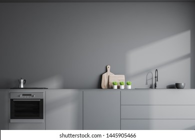 Interior of stylish kitchen with gray walls, grey countertops with built in sink and oven and wooden cutting boards with plants near them. 3d rendering