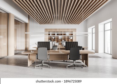 Interior Of Stylish Open Space Office With White And Wooden Walls, Concrete Floor, Row Of Computer Tables And Bookcase. 3d Rendering