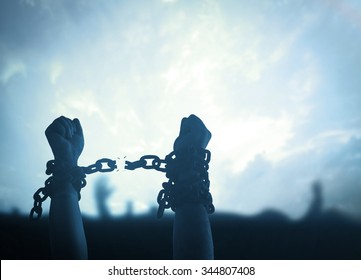 International Day For The Remembrance Of The Slave Trade And Its Abolition Concept: Silhouette Human Hands Raising And Broken Chains At Night Background