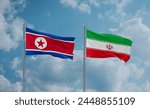 Iran and North Korea flags waving together on blue cloudy sky