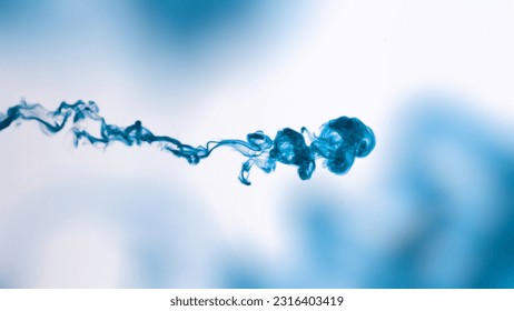 Isolated Blue Ink Cloud floating in clear water. Macro Shot on White Background with selective focus framed for vertical video