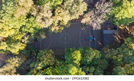 Kids Playing Basketball In The Park, 4K Aerial Top-down View Of A Basketball Court Surrounded By The Green Trees.