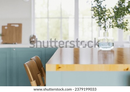 Kitchen with green cabinets, large window in the background and accent countertop to advertise the product. Kitchen island with blurry long shot of green kitchen. 3D rendering. 3D Illustration