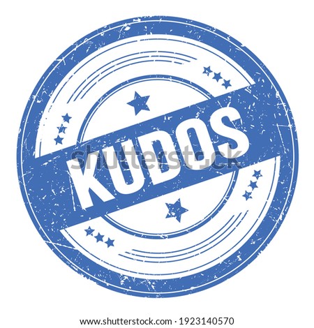 KUDOS text on blue round grungy texture stamp.