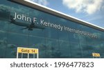 Landing airplane reflects in the modern windows with john f. kennedy international airport text 3D rendering