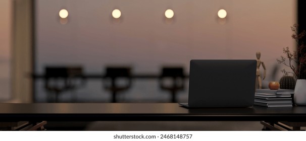 A laptop computer and decorative objects on a black table in a modern, luxurious meeting room at sunset. back view image. 3d render, 3d illustration