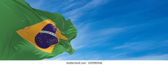 Large flag of Brazil  waving in the wind against the sky with clouds on sunny day. 3d illustration - Powered by Shutterstock