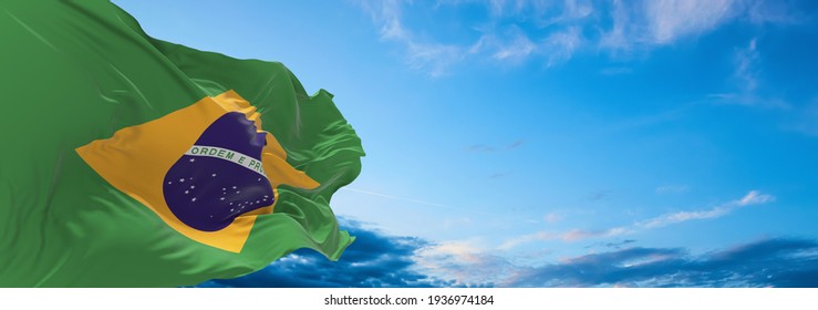 Large flag of Brazil  waving in the wind on flagpole against the sky with clouds on sunny day. 3d illustration - Powered by Shutterstock