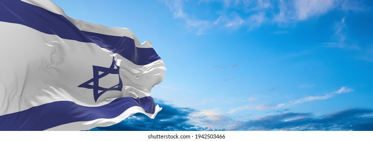 Large flag of Israel  waving in the wind on flagpole against the sky with clouds on sunny day. 3d illustration