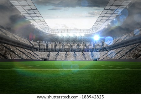 Large football stadium with lights under cloudy sky