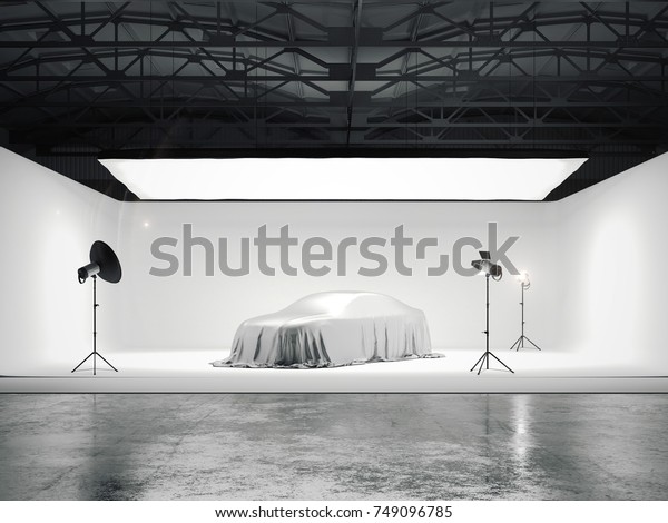 Large photographic studio with a covered car\
and several light sources. 3d\
rendering