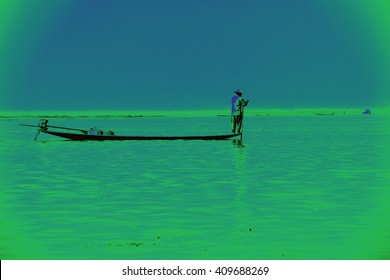 Leg Rowing Fisherman And His Nets In A Small Boat On Inlet Lake,  Myanmar (Burma)