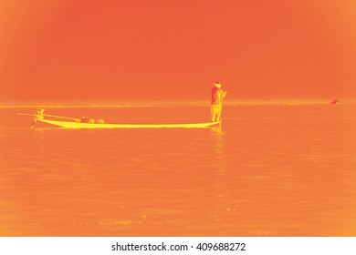 Leg Rowing Fisherman And His Nets In A Small Boat On Inlet Lake,  Myanmar (Burma)