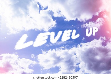Level up. Text from clouds in sky in bright sunlight..