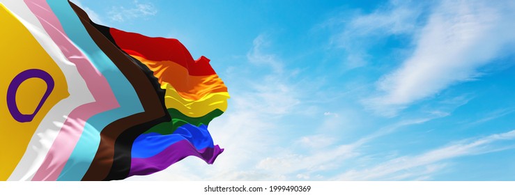 LGBTQ Progress Pride With Intersex Inclusion Flag Waving In The Wind At Cloudy Sky. Freedom And Love Concept. Pride Month. Activism, Community And Freedom Concept. Copy Space. 3d Illustration.