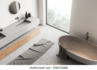 Light Bathroom Interior, Top View, Grey Tub With Towel, Sink With Mirror, Concrete Floor. Modern Bathing Room And Panoramic Window With Nature View, 3D Rendering No People