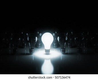 light bulbs stand in rows one glows on a dark background. 3D render