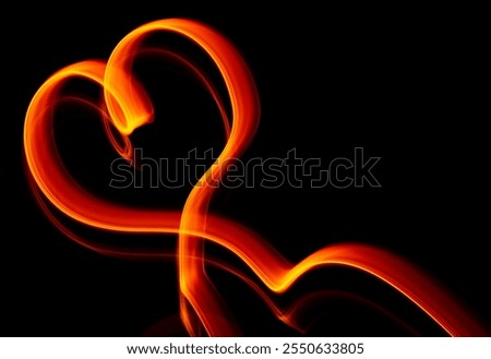 Light wave trail path, vibrant neon gold color in abstract swirls on a black background. Light painting. Heart shape