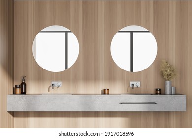 Light wooden bathroom with two sinks and round mirrors, front view. Minimalist beige and grey design of modern bathroom 3D rendering, no people