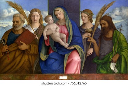 MADONNA AND CHILD SAINTS, By Giovanni Bellini, 1460-1516, Italian Renaissance Oil & Tempera Painting. St. Peter, St. John The Baptist, And Two Angles Flank Mary And Jesus. Bellini Painted With Luminou