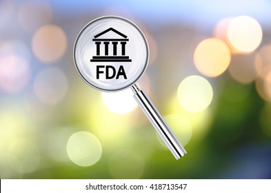 Magnifying lens over background with building icon and text FDA, with the blurred lights visible in the background. 3D rendering.
