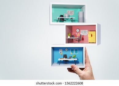 A man Holding up a stack of miniature business office rooms. Business workplace 3D concept illustration. - Powered by Shutterstock