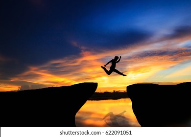 Man jumping over cliff on sunset background,Business concept idea - Shutterstock ID 622091051