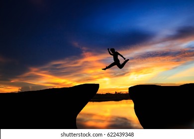 Man jumping over cliff on sunset background,Business concept idea - Shutterstock ID 622439348
